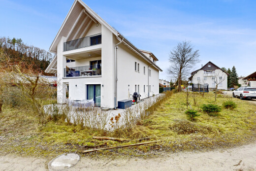 façade avec day time, balcon, bardage en stuc, terrain vierge, et property visible