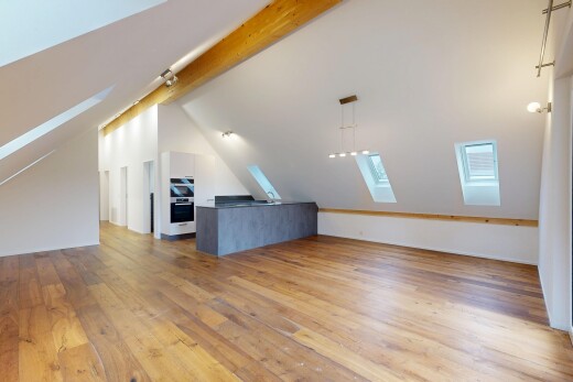 empty room featuring a skylight, light wood-style floors, and vaulted ceiling with beams