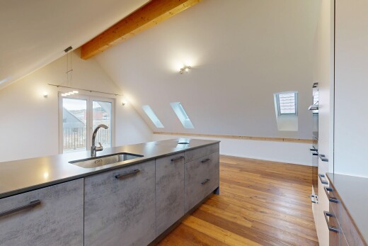 kitchen featuring light wood-style flooring, beam ceiling, light countertops, gray cabinetry, and a skylight