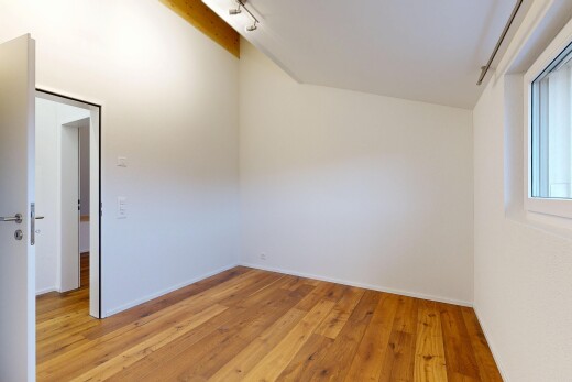 unfurnished room featuring light wood-type flooring, track lighting, and lofted ceiling