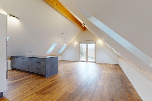 spare room with a skylight, light wood-style floors, and vaulted ceiling with beams