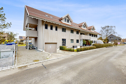 view of home with an attached garage, a tile roof, and board and batten siding