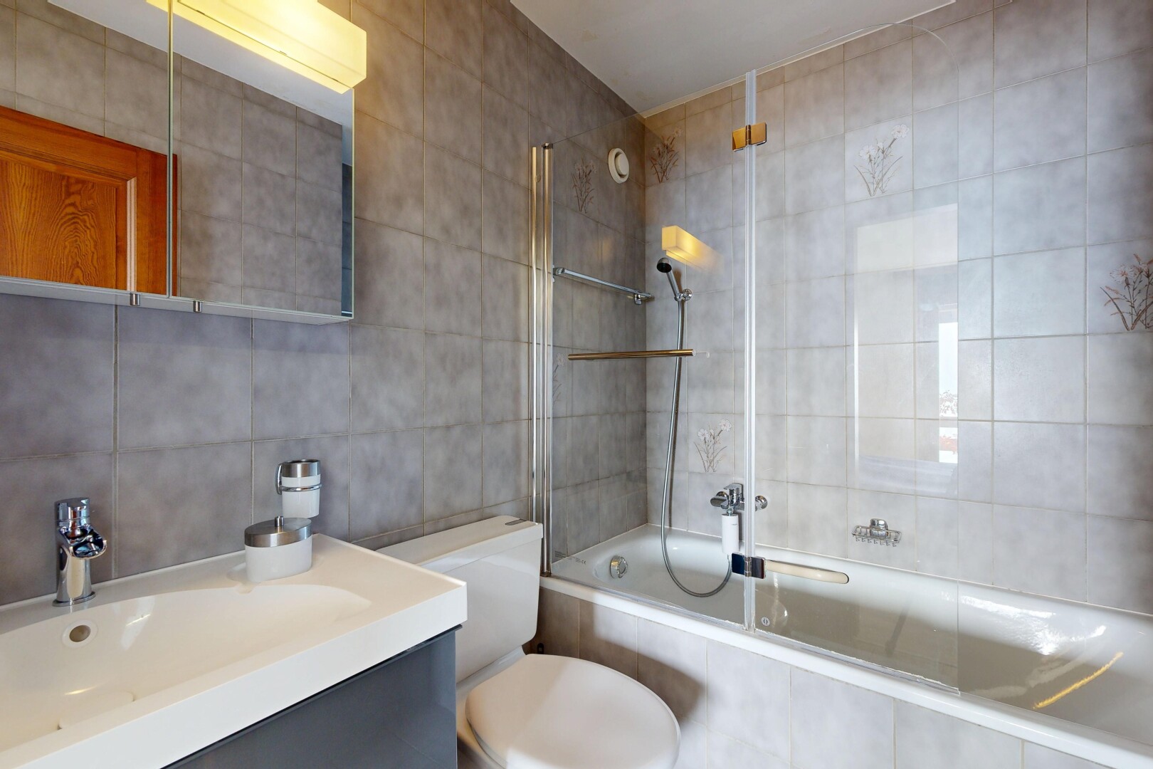 bathroom with tiled shower / bath, tile walls, and vanity