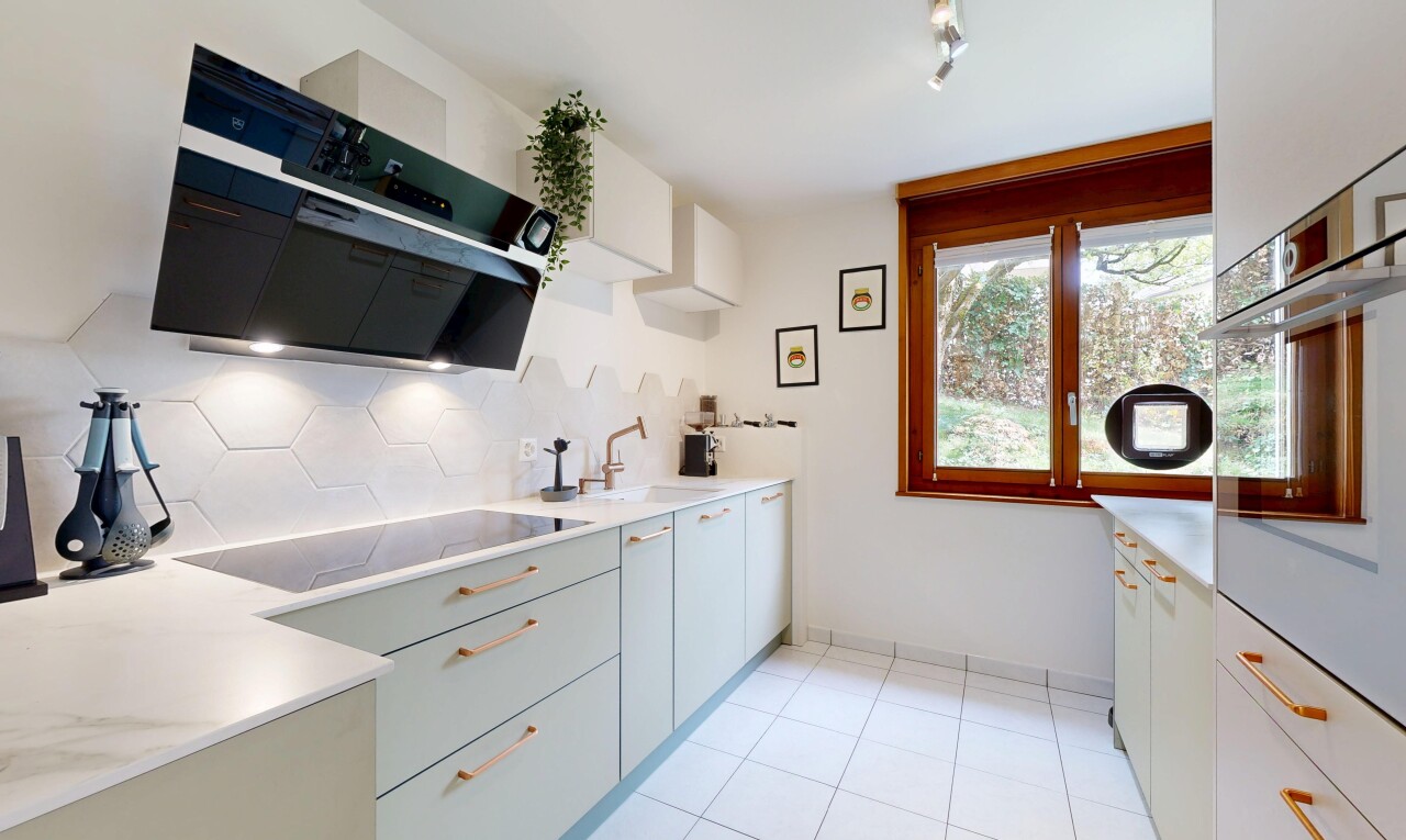 kitchen featuring track lighting, range hood, black electric stovetop, oven, and light tile patterned flooring