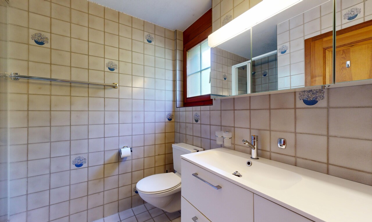 bathroom with a shower stall, tile walls, vanity, and light tile patterned floors