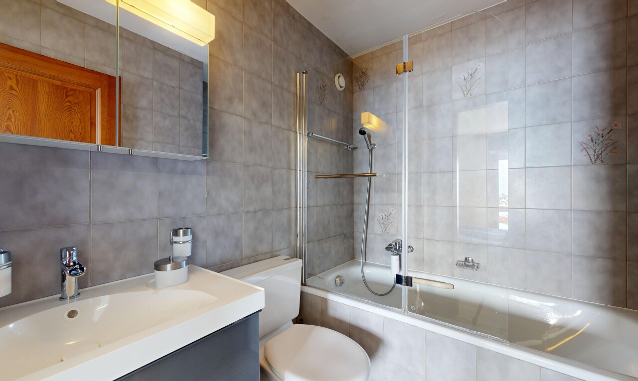 bathroom with tiled shower / bath, tile walls, and vanity
