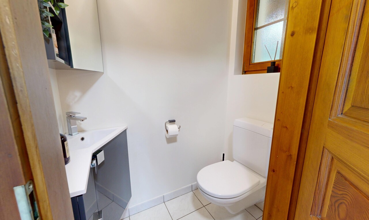half bath with light tile patterned flooring and vanity