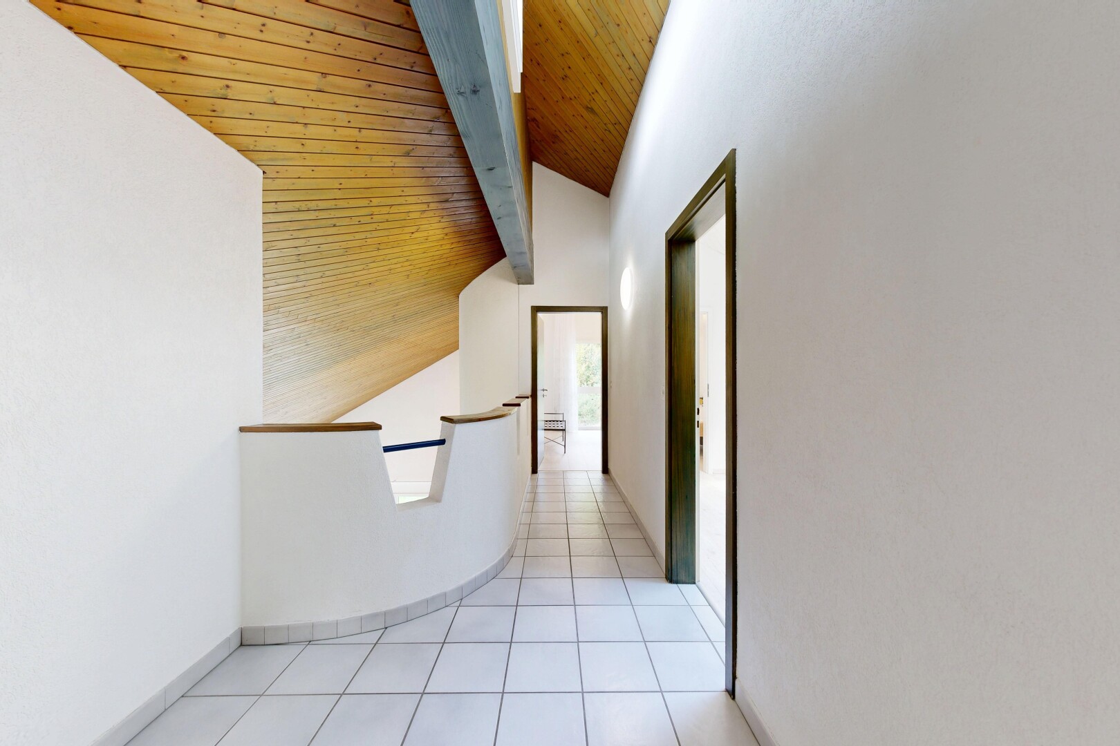couloir avec cloison sèche, drywall, inside community, sol en carrelage, et tile floor