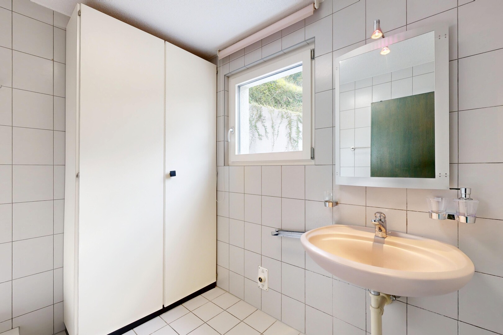 salle de bains avec mur en carrelage, tile wall, miroir, lumière naturelle, et natural light