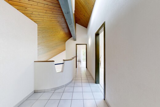 couloir avec cloison sèche, drywall, inside community, sol en carrelage, et tile floor