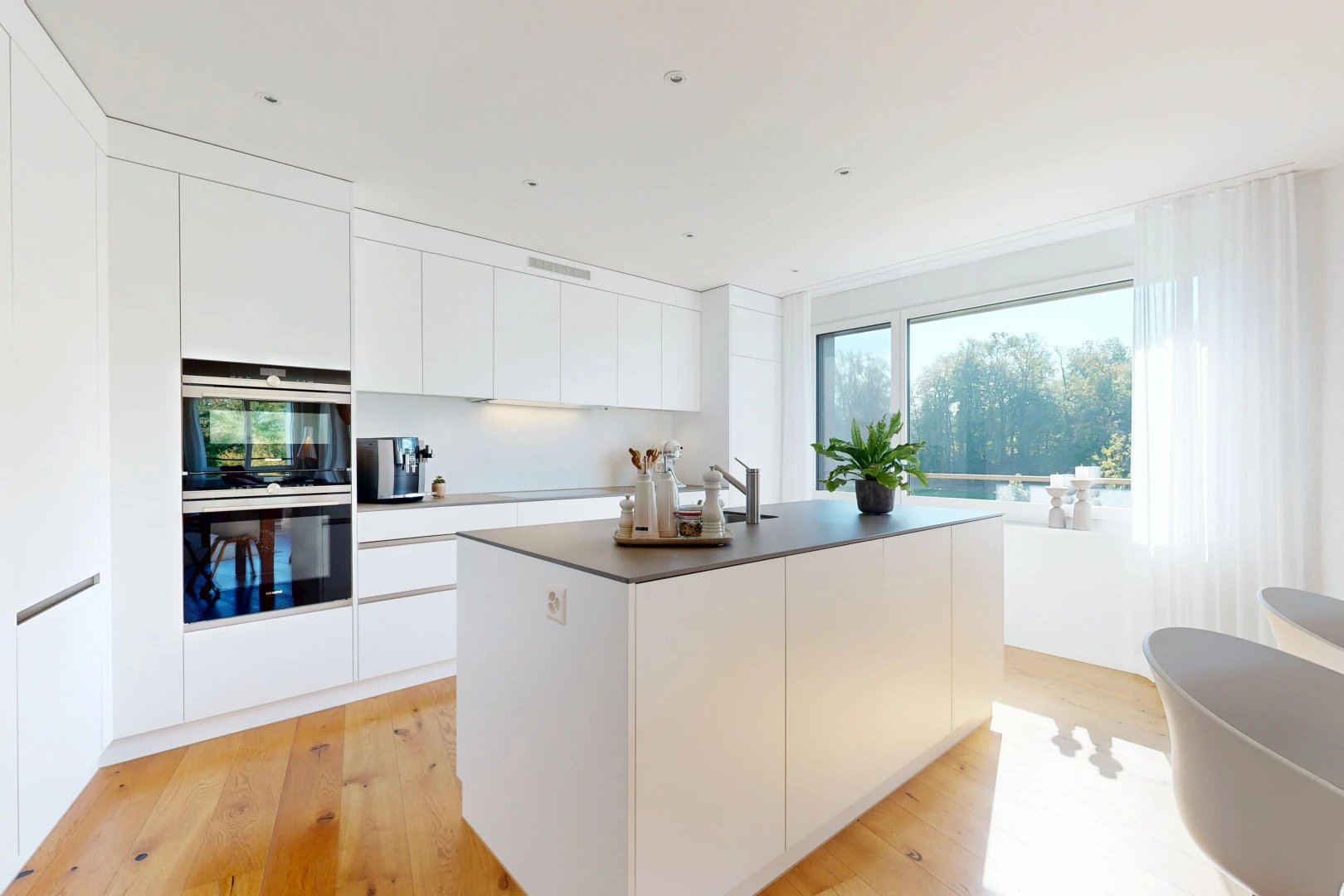 kitchen featuring modern cabinets, white cabinets, a kitchen island with sink, and light wood-type flooring
