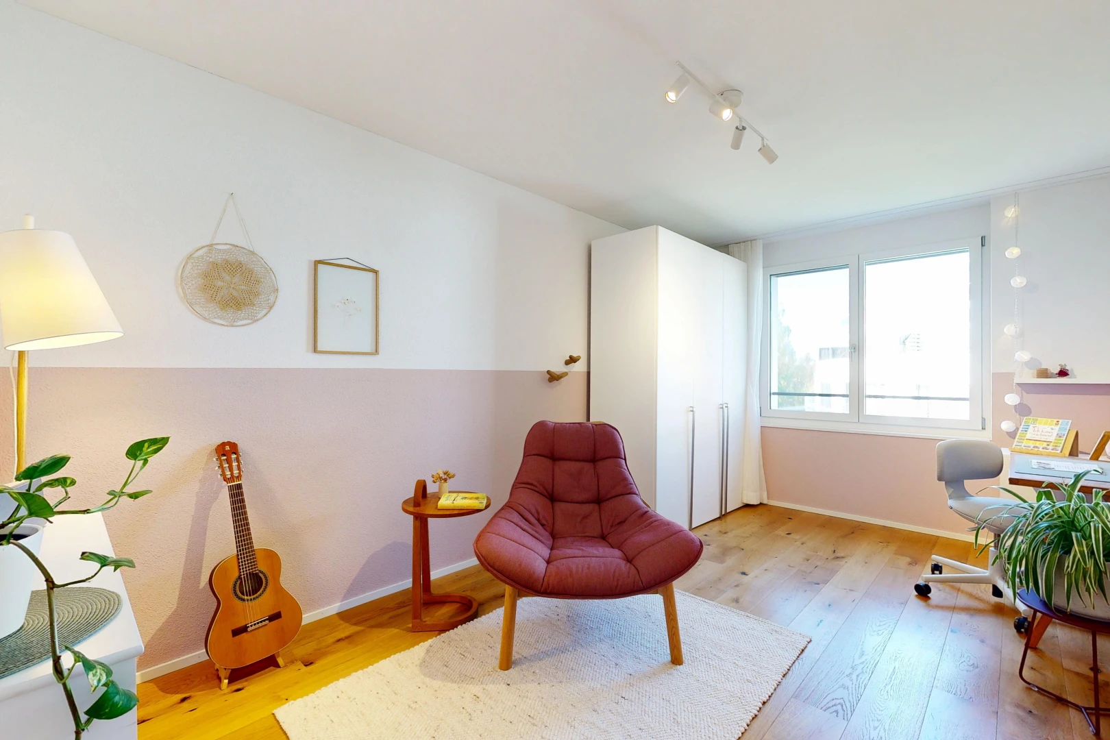 living area with light wood-style flooring and track lighting