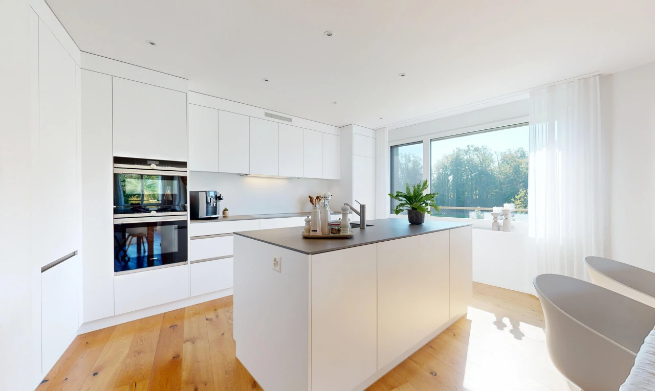 kitchen featuring modern cabinets, white cabinets, a kitchen island with sink, and light wood-type flooring