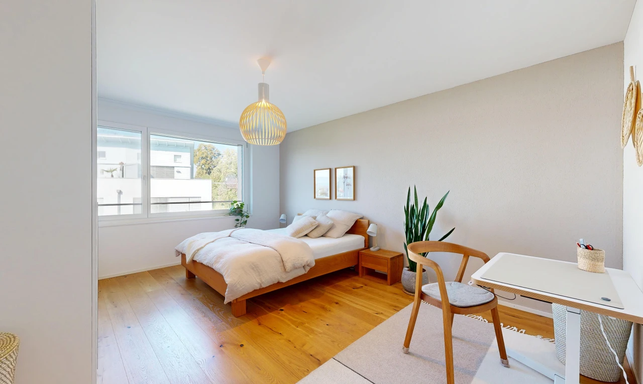 room featuring an office area, light wood-style flooring, and decorative light fixtures