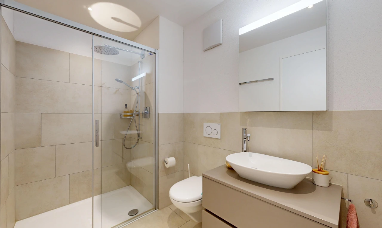 full bathroom featuring a stall shower, vanity, and tile walls