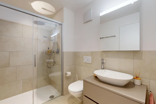 full bathroom featuring a stall shower, vanity, and tile walls