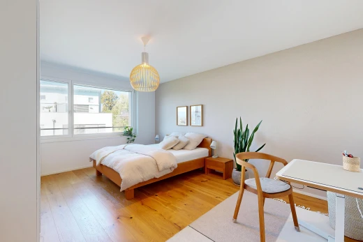 room featuring an office area, light wood-style flooring, and decorative light fixtures