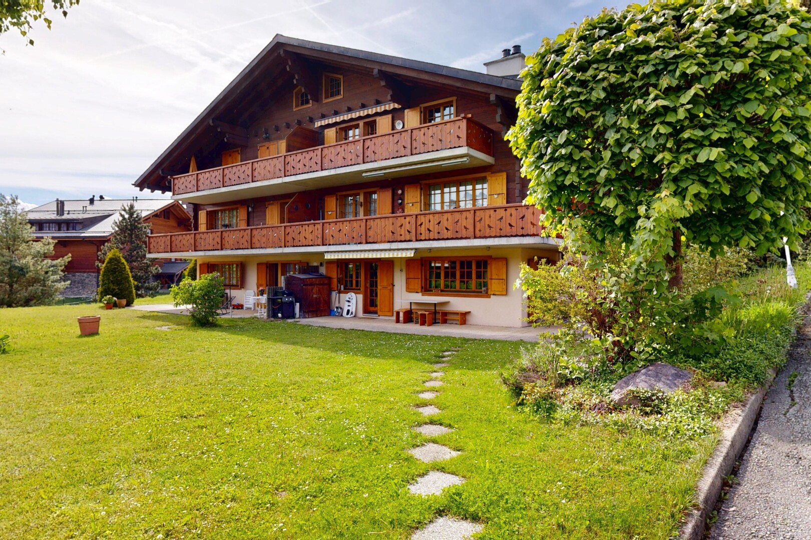 façade avec balcon, terrasse, pelouse, et property visible