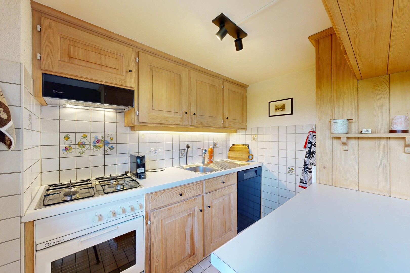cuisine avec plans de travail, light countertops, armoires marron clair, light brown cabinets, et armoires élevées