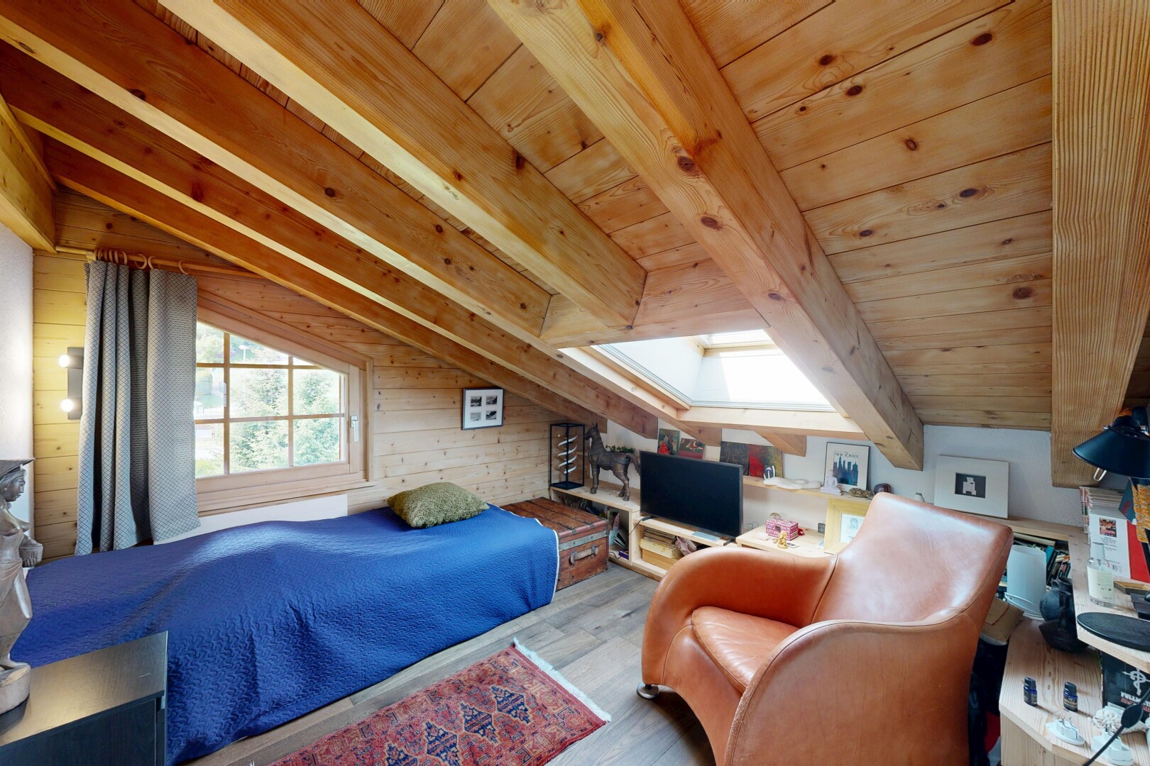 chambre avec sol en finition bois, wood finish floor, inside property, télévision, et pièce supplémentaire