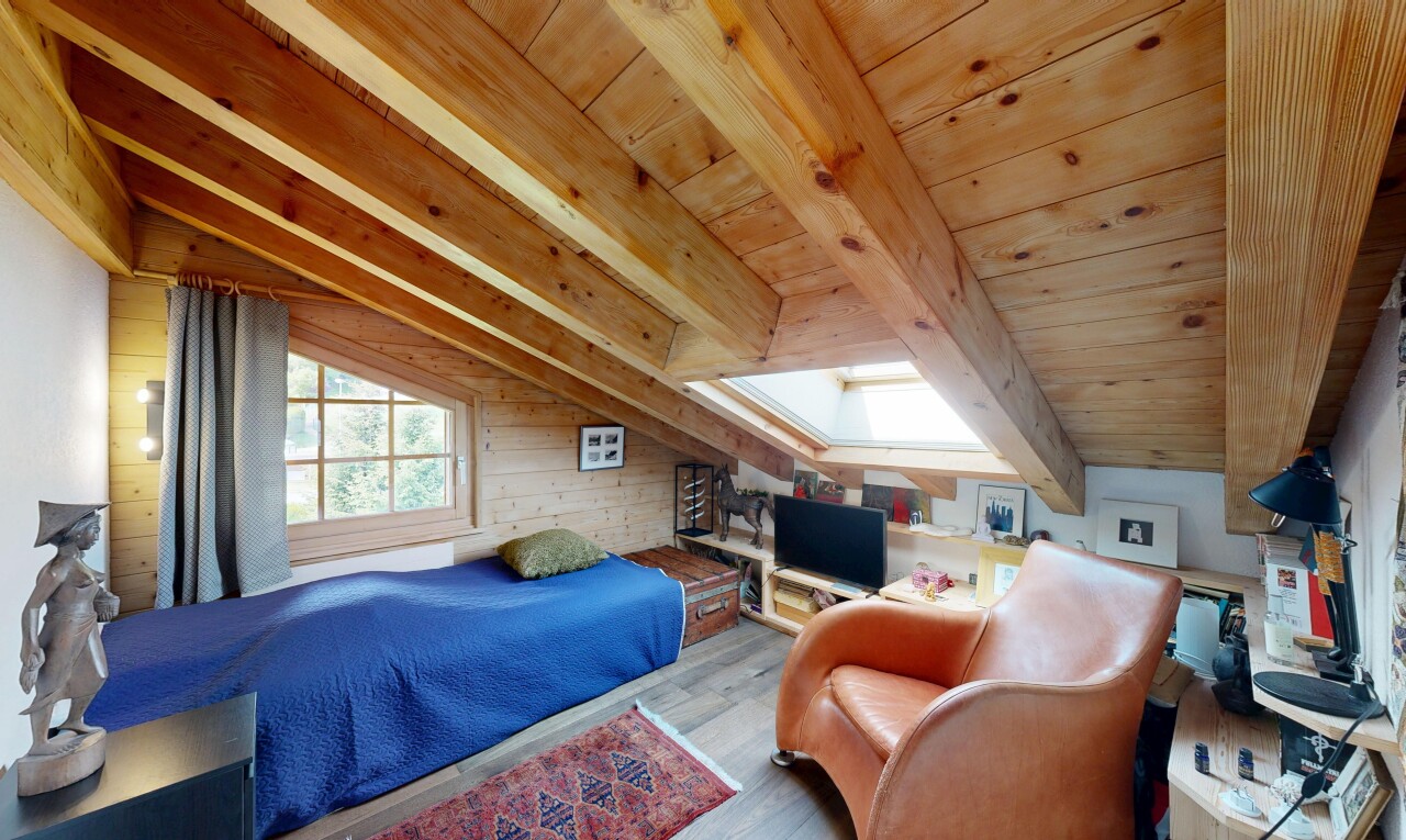 chambre avec sol en finition bois, wood finish floor, inside property, télévision, et pièce supplémentaire