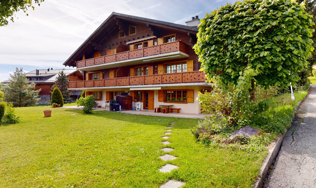 façade avec balcon, terrasse, pelouse, et property visible