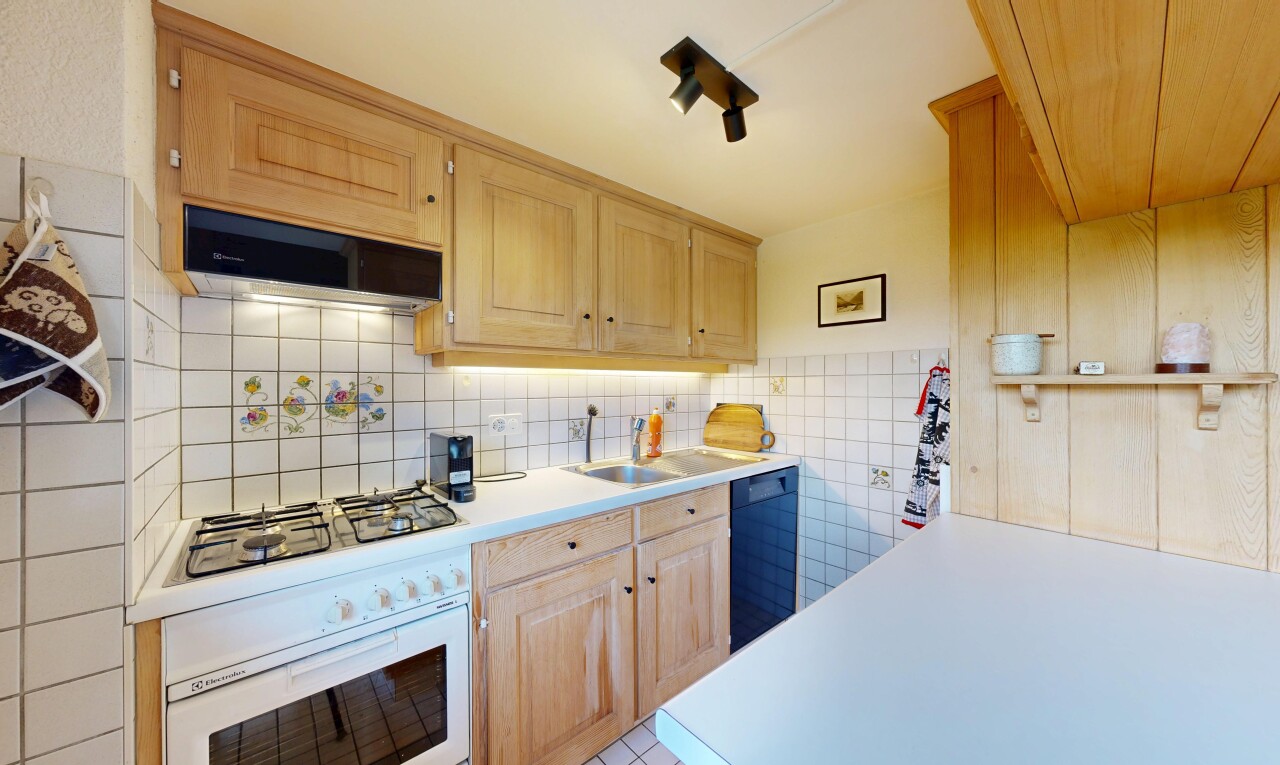 cuisine avec plans de travail, light countertops, armoires marron clair, light brown cabinets, et armoires élevées