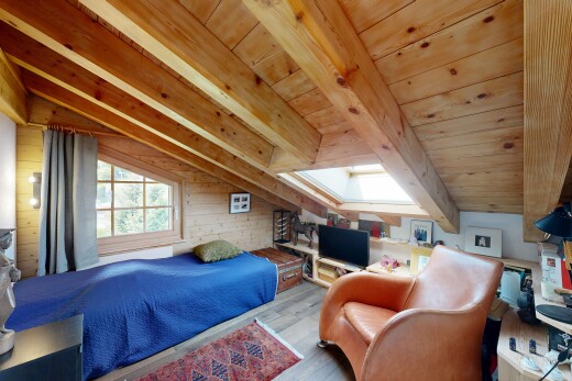 chambre avec sol en finition bois, wood finish floor, inside property, télévision, et pièce supplémentaire