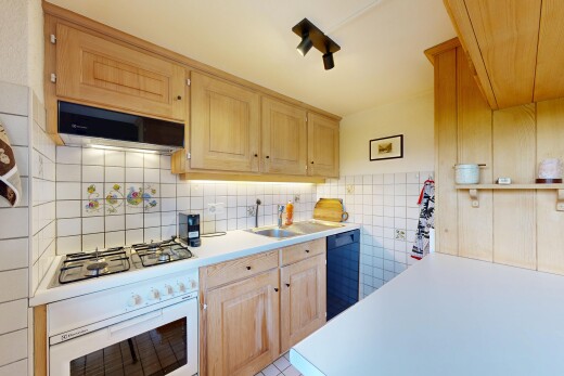 cuisine avec plans de travail, light countertops, armoires marron clair, light brown cabinets, et armoires élevées
