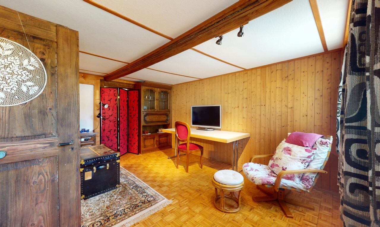 salon avec télévision, parquet floor, inside property, wood wall, et mur en bois