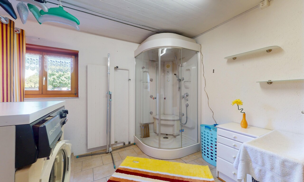 salle de bains avec drywall, cloison sèche, inside community, douche, et tile floor
