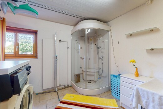 salle de bains avec drywall, cloison sèche, inside community, douche, et tile floor