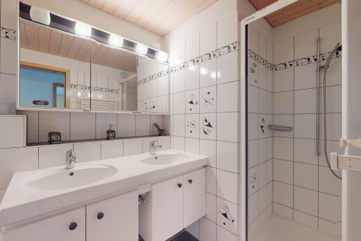 salle de bains avec évier, tile wall, mur en carrelage, douche, et inside property