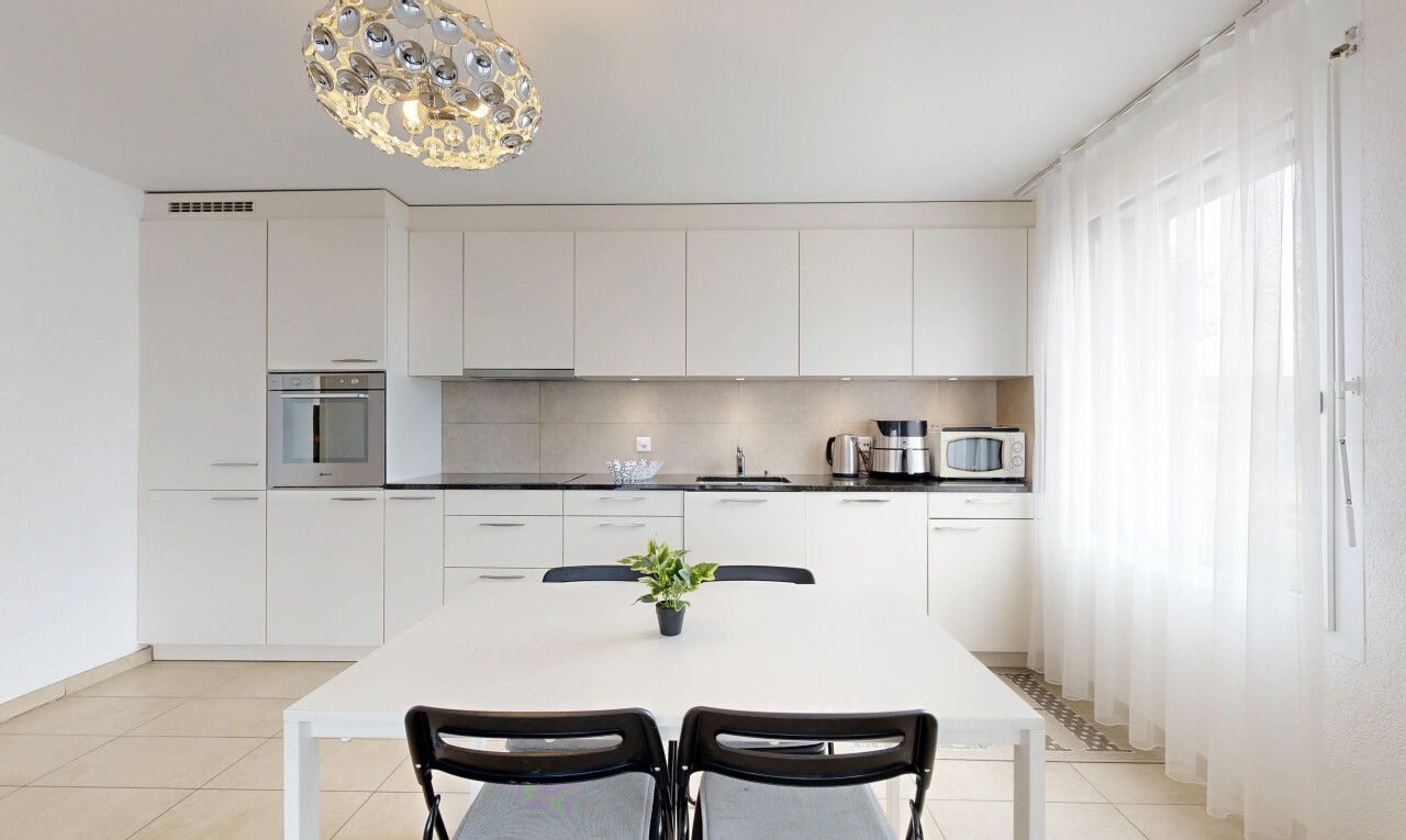 cuisine avec sol en carrelage, tile floor, armoires blanches, lumière naturelle, et natural light