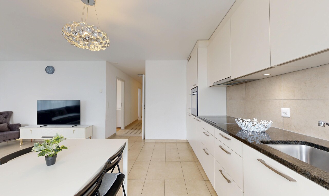 cuisine avec lustre remarquable, armoires blanches, télévision, tile floor, et sol en carrelage