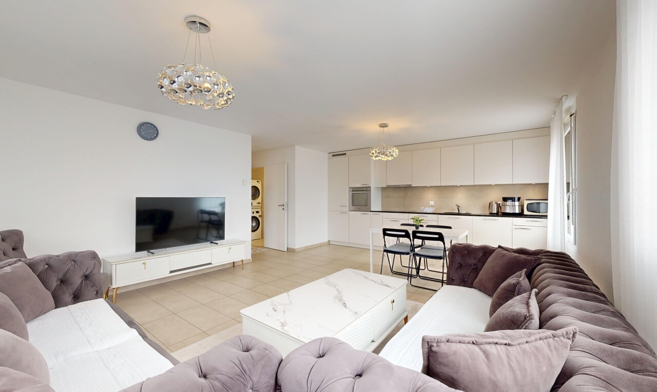 salon / salle à manger avec lustre remarquable, télévision, drywall, cloison sèche, et inside property