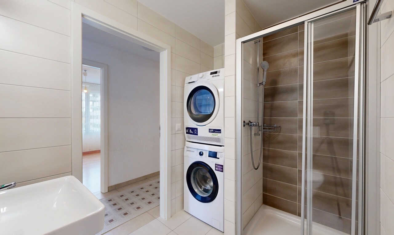 buanderie avec inside property, buanderie, lave-linge et sèche-linge superposés, tile floor, et sol en carrelage