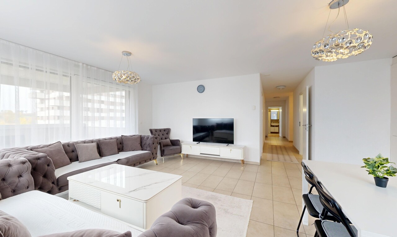 salon avec lustre remarquable, télévision, cloison sèche, drywall, et inside property