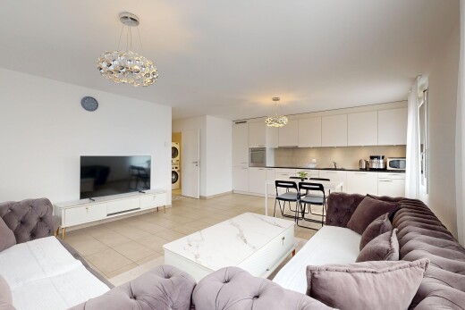 salon / salle à manger avec lustre remarquable, télévision, drywall, cloison sèche, et inside property