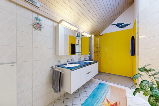 salle de bains avec tile wall, mur en carrelage, double vasque, light floor, et miroir