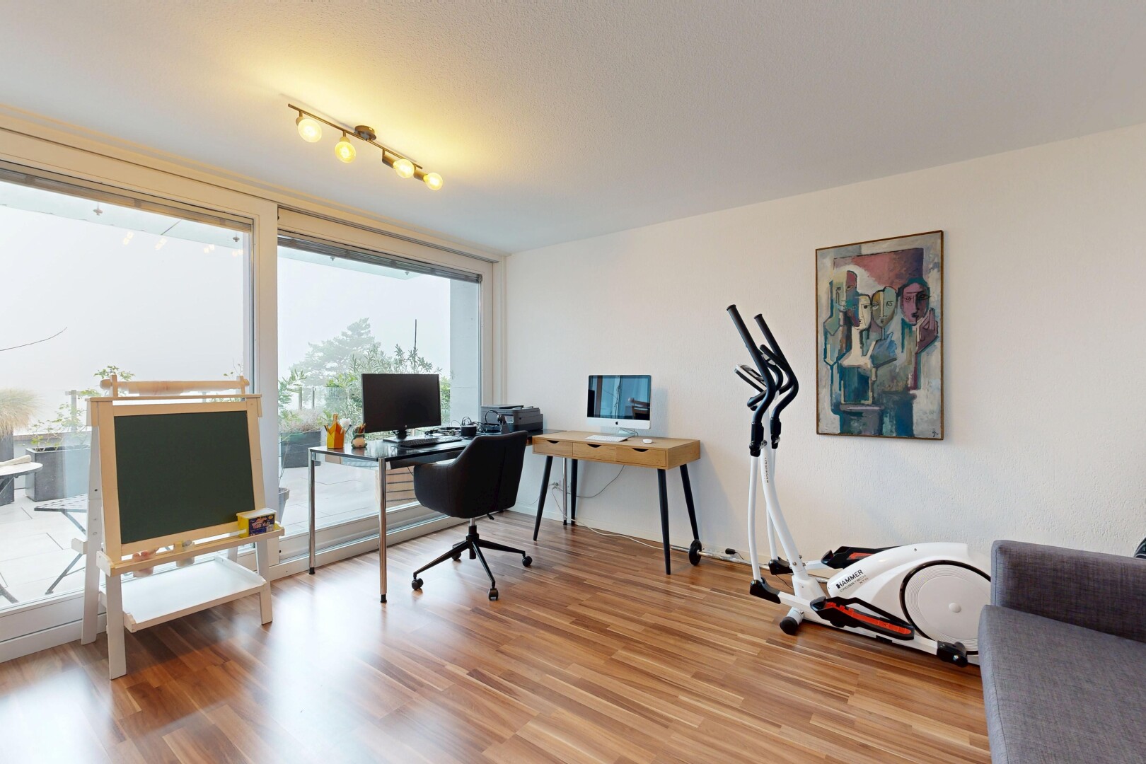 bureau avec espace bureau, sol en finition bois, cloison sèche, drywall, et wood finish floor