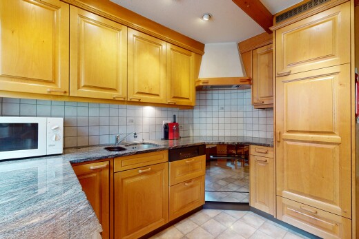 küche mit mikrowelle, dunstabzugshaube, inside property, stein arbeitsplatten, und waschbecken