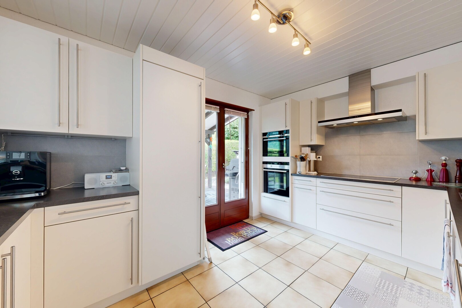 cuisine avec plans de travail, dark countertops, hotte, light floor, et inside property