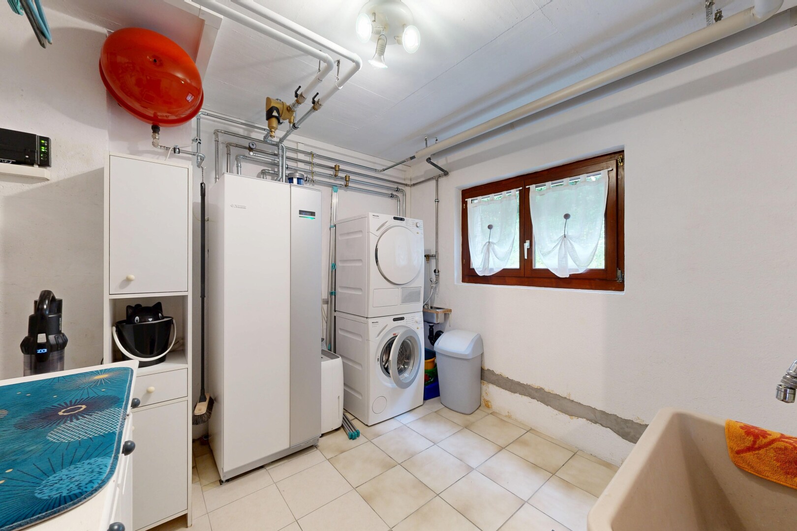 buanderie avec drywall, cloison sèche, lave-linge et sèche-linge superposés, light floor, et inside property