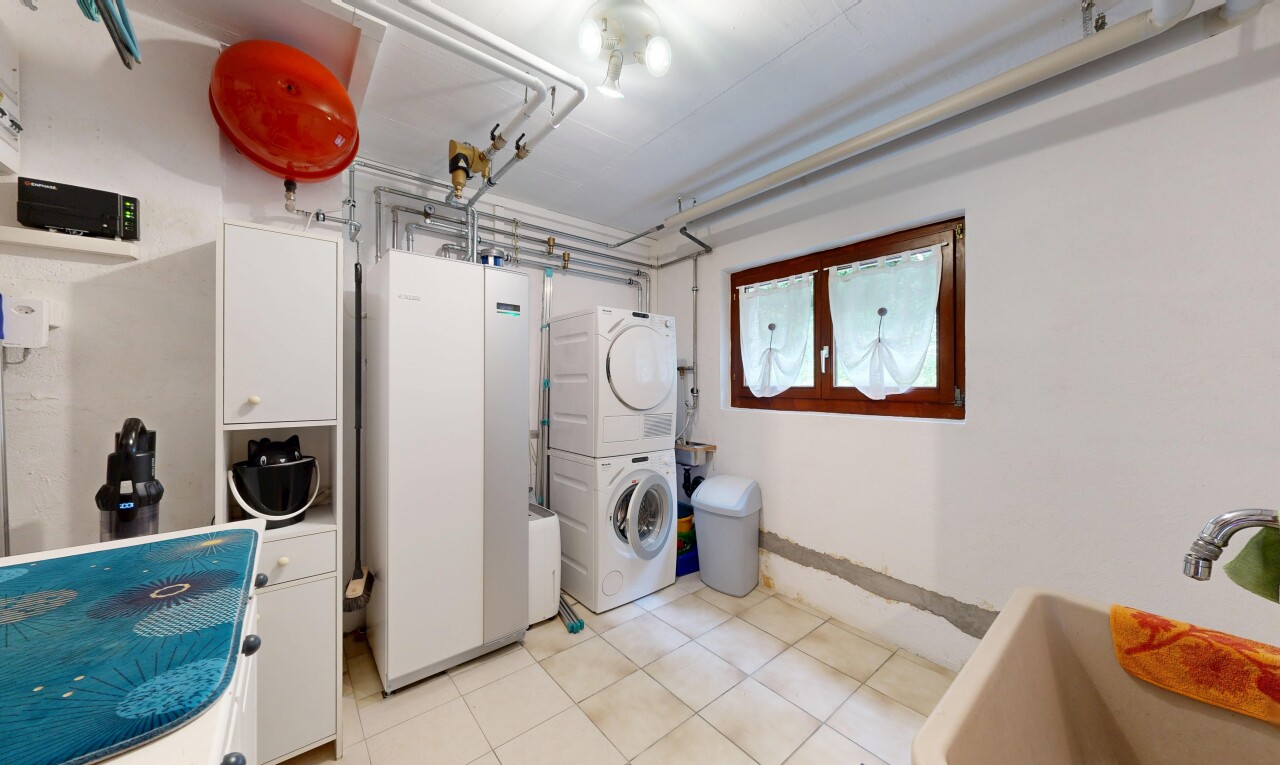 buanderie avec drywall, cloison sèche, lave-linge et sèche-linge superposés, light floor, et inside property