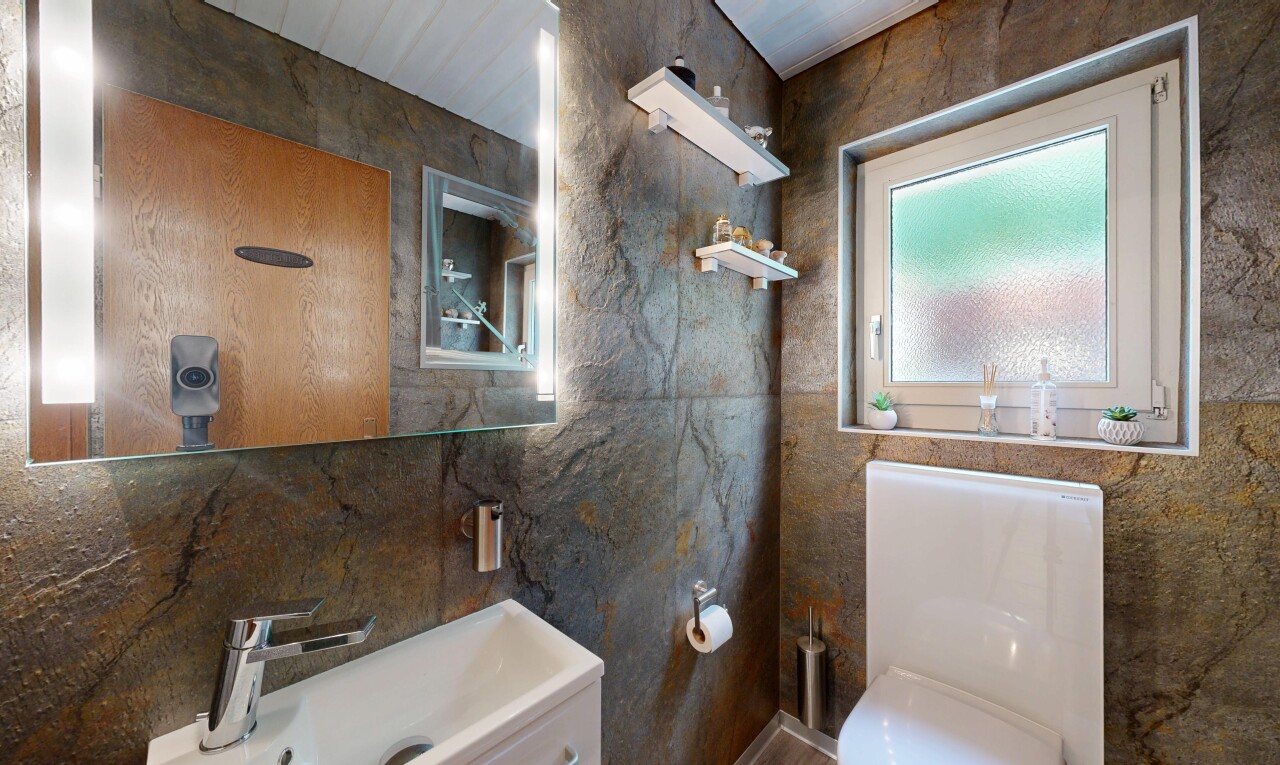 salle de bains avec toilette, natural light, lumière naturelle, miroir, et tile wall