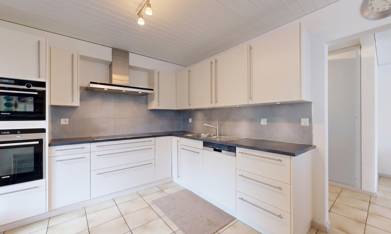 cuisine avec dosseret, backsplash, hotte, light floor, et plans de travail