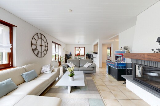 salon avec cheminée, tile floor, sol en carrelage, drywall, et cloison sèche