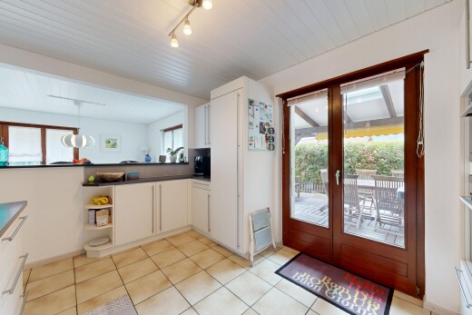 cuisine avec dark countertops, plans de travail, light floor, white cabinets, et armoires blanches