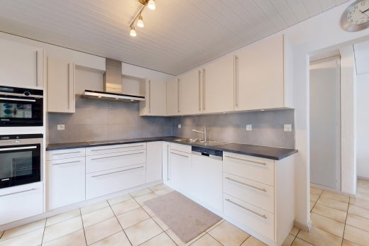 cuisine avec dosseret, backsplash, hotte, light floor, et plans de travail